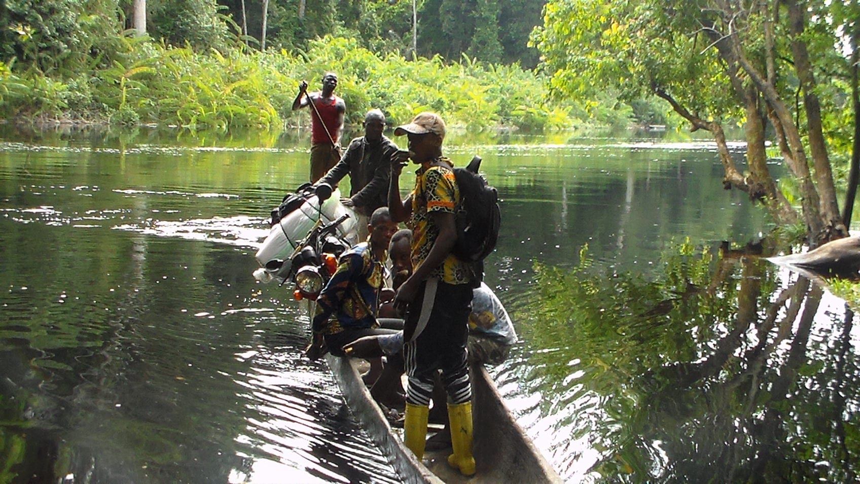 Village Enterprise staff traveling across a river in a canoe 