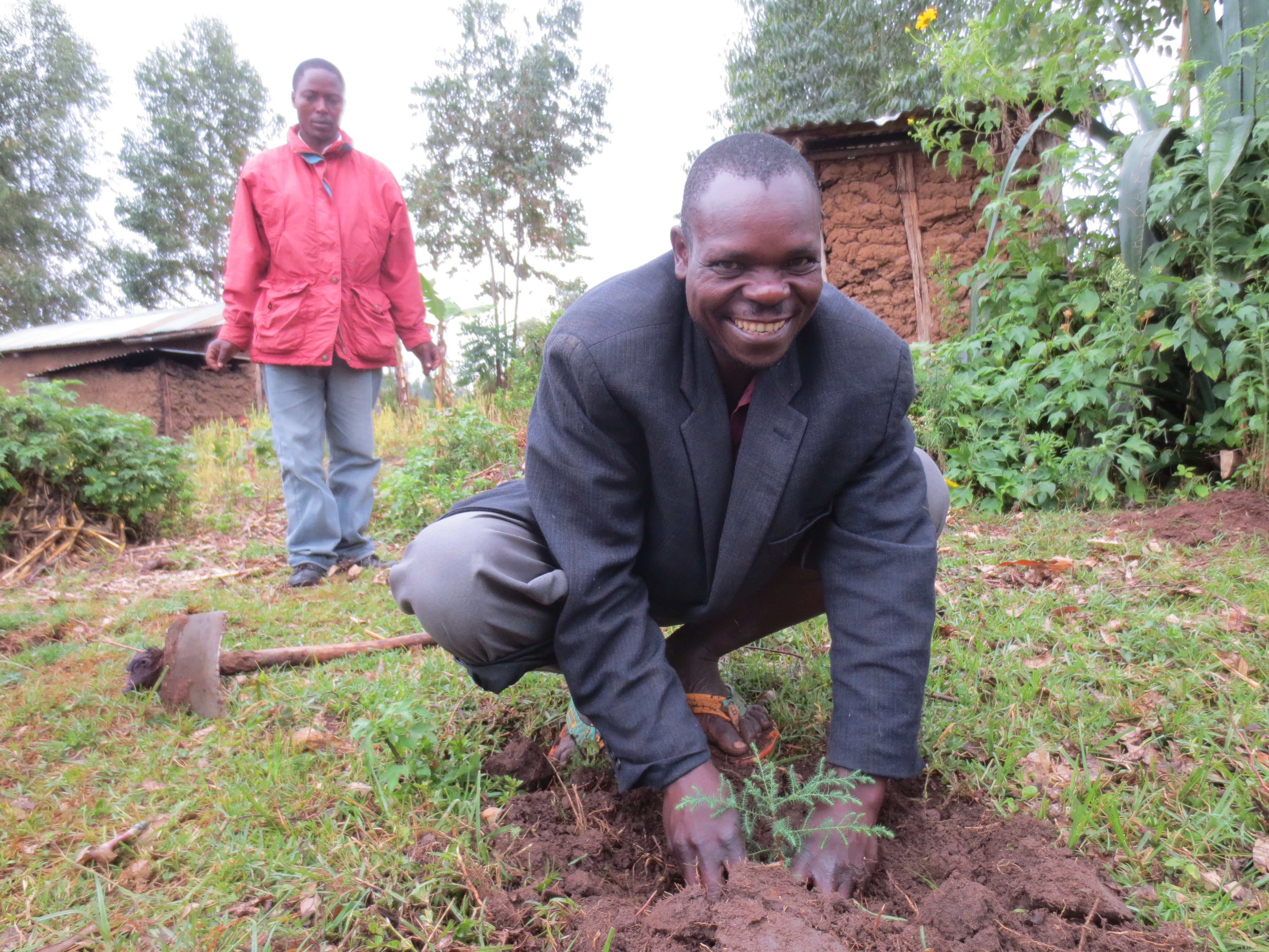 Village Enterprise Business Savings Group Secretary John Mbita Smiyu plants a tree