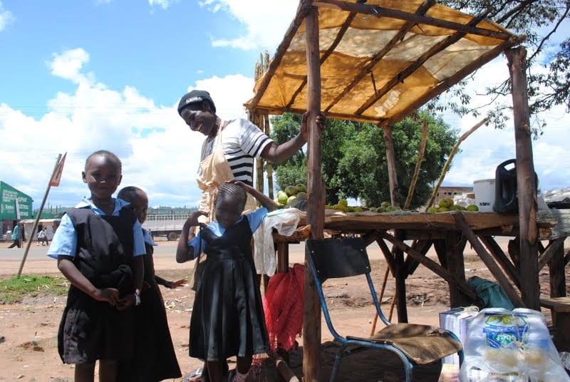 Village Enterprise business owner Elamina Mada and her children in school uniforms