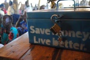 Village Enteprise savings box labeled "Save money, live better"