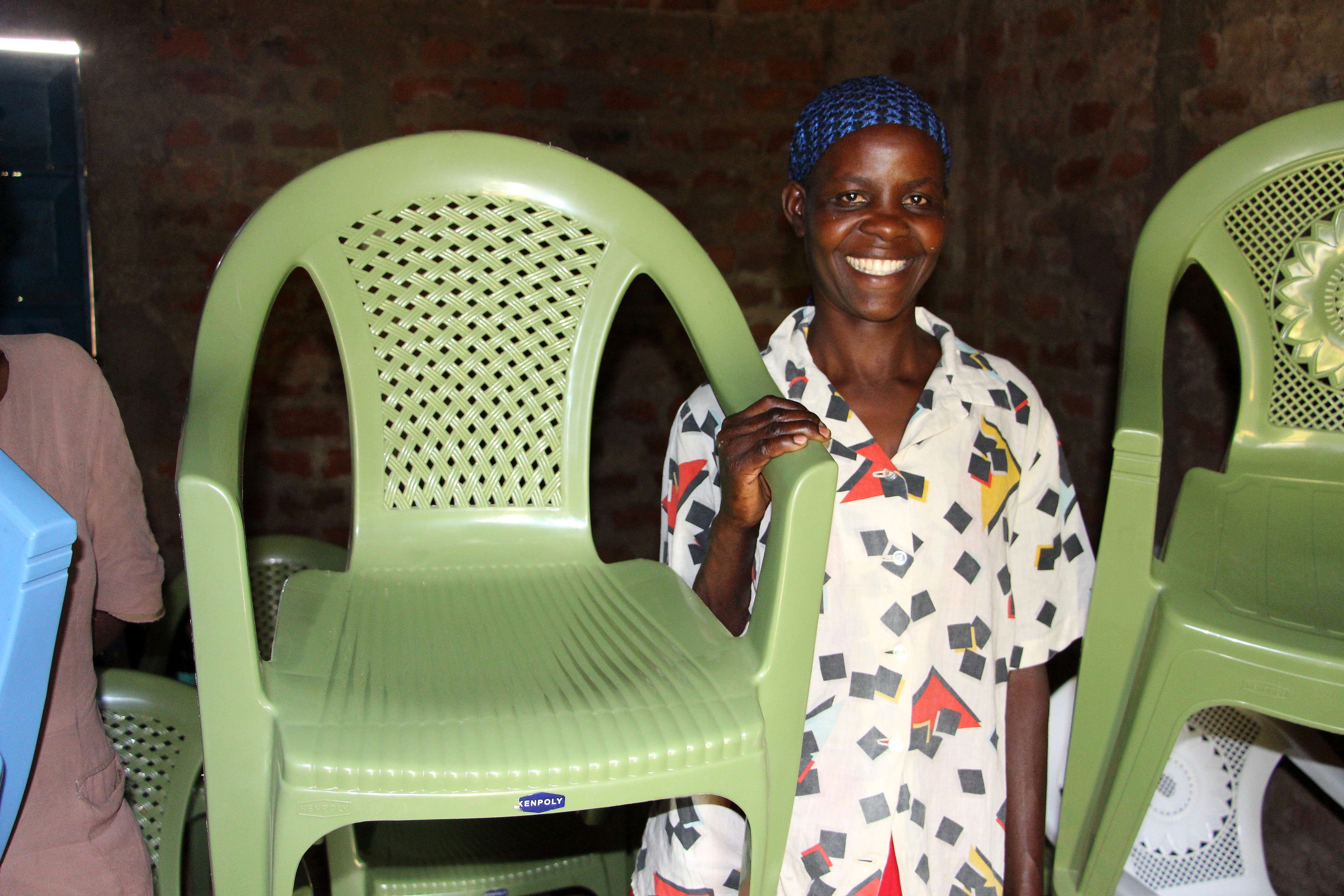 Lydya Nanjala shows off one of the plastic chairs her Village Enterprise business savings group rents out for events