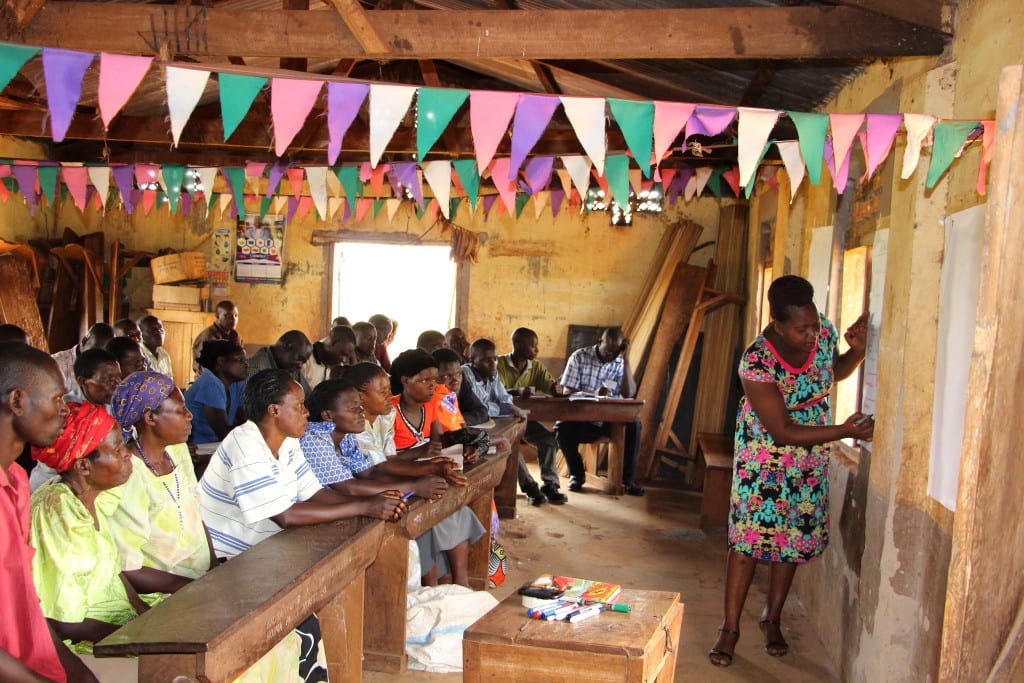 Village Enterprise Business Mentor Evelyne Kusiima leads a business savings group training for Community Based Forest Monitors in Bulimya Village, Uganda.